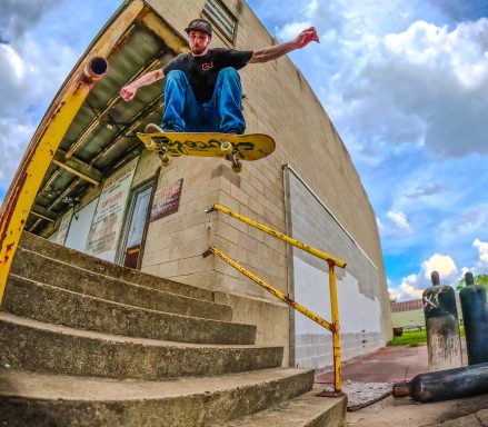 Skateboarder jumping over a set of stairs, performing a trick in mid-air.