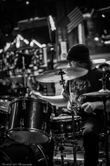 Black and white photo of a drummer performing on stage.